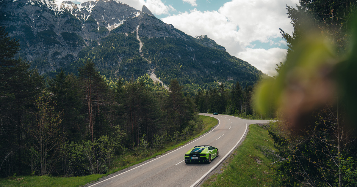 A green Lamborghini Huracan exploring some country roads in Europe