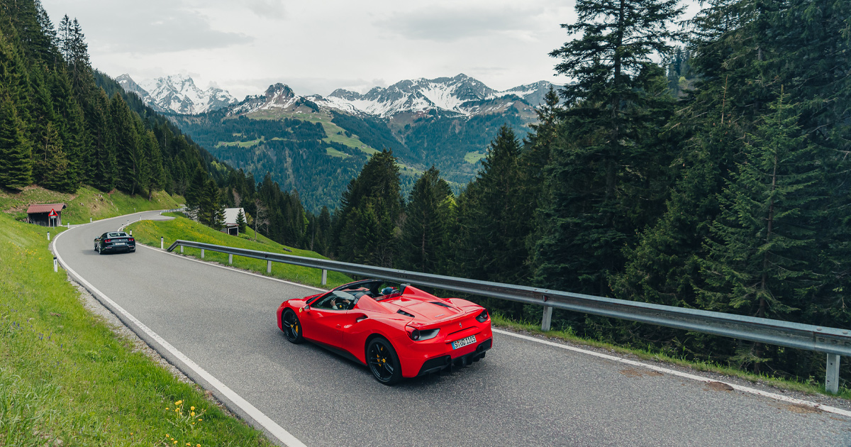 A red Ferrari 488 Spyder descending on a high alpine road in Germany