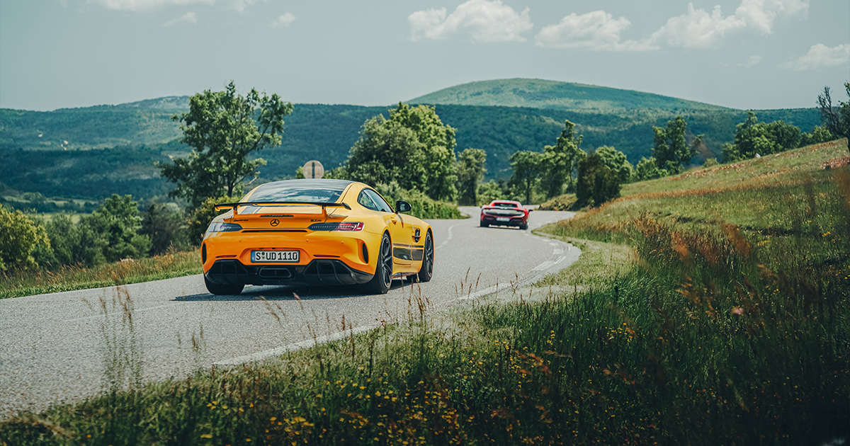 A yellow Mercedes AMG GTR carving up a French country road