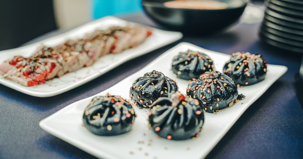 Black sesame dumplings neatly arranged on a white plate