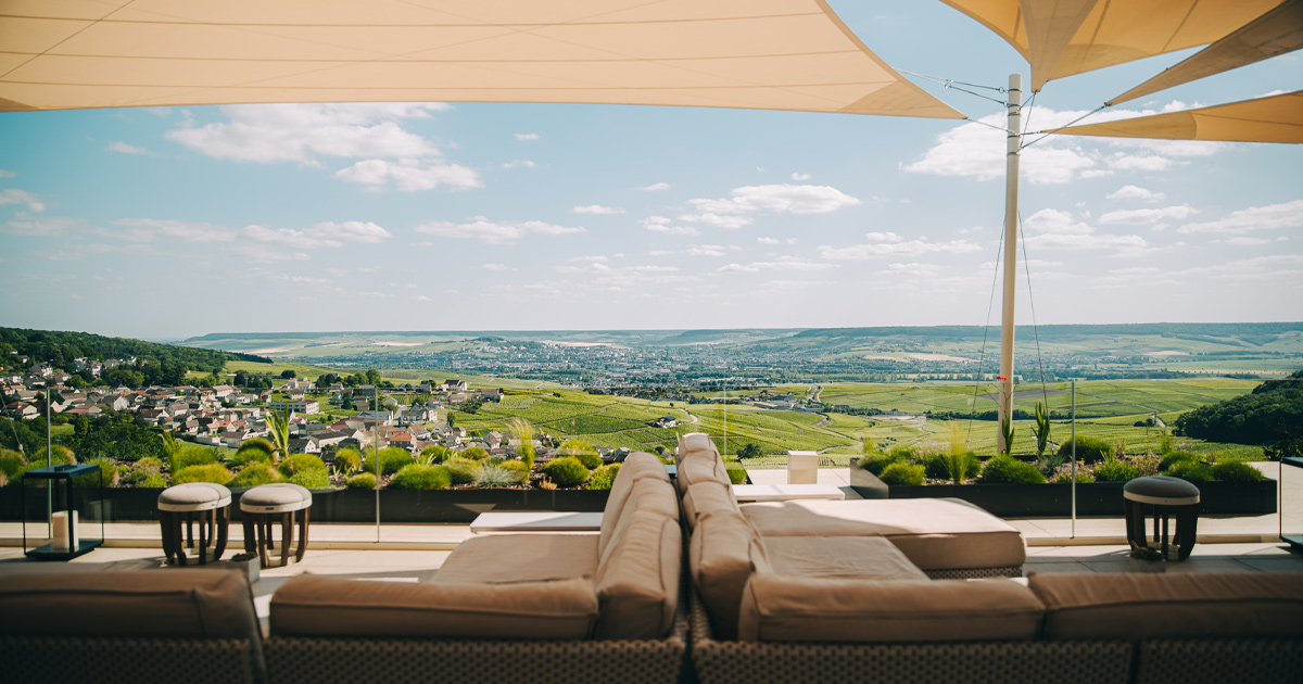 A panorama of green valleys and vineyards in the French countryside with al fresco furniture in the foreground
