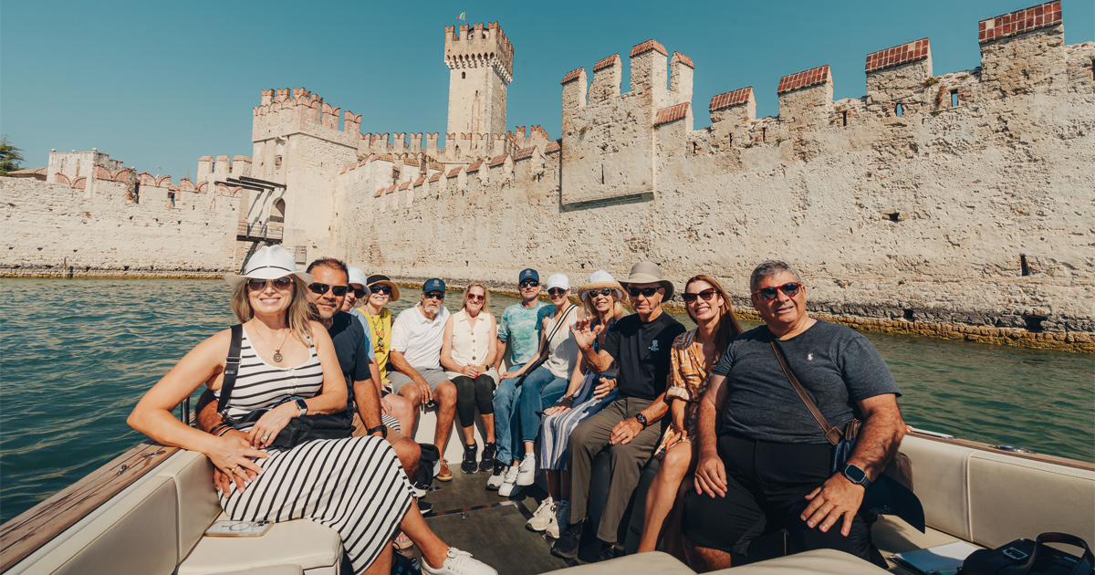 A happy group of guests on a boat exploring an ancient castle with Ultimate Driving Tours