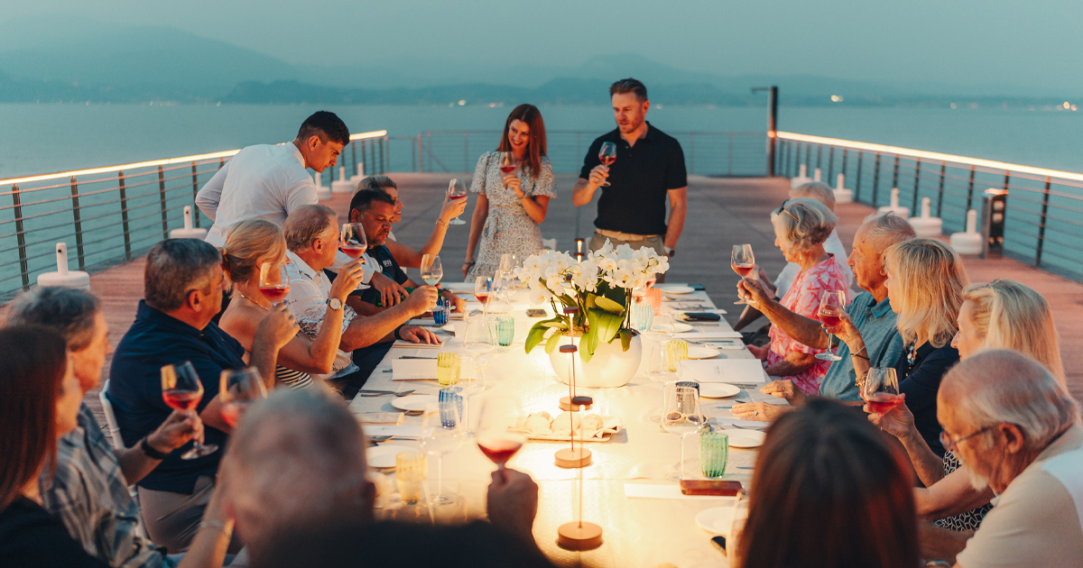 Anthony Moss and Julie Hunter address tour guests at an Ultimate Driving Tours evening meal on a pier