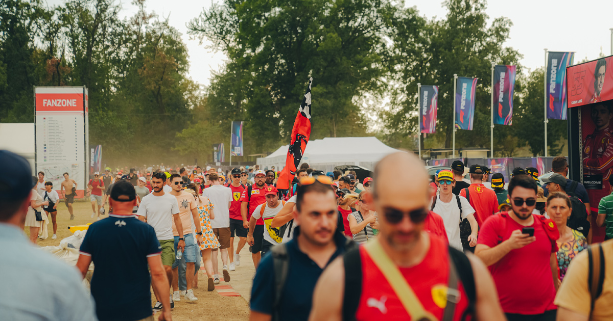 A large crowd moving around the Monza F1 track, many dressed in Ferrari red.