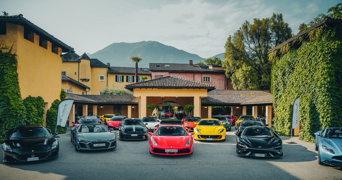 The Ultimate Driving Tours fleet of supercars parked outside a large yellow luxury villa at Castello del Sole
