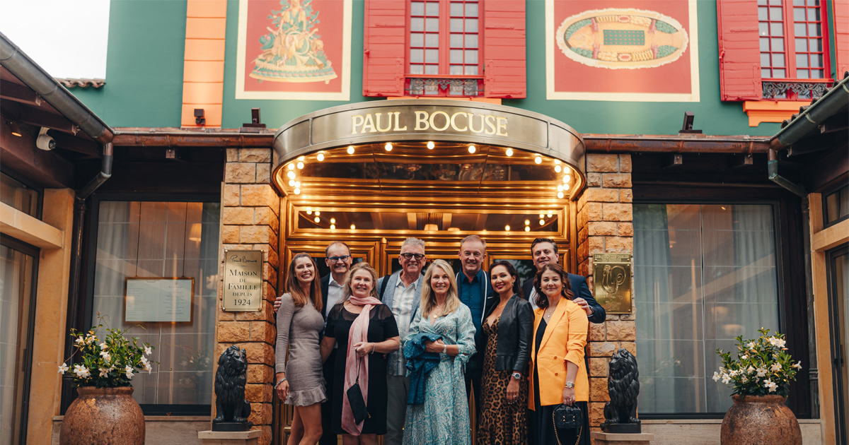 Ultimate Driving Tours guests outside the entrance to Restaurant Paul Bocuse