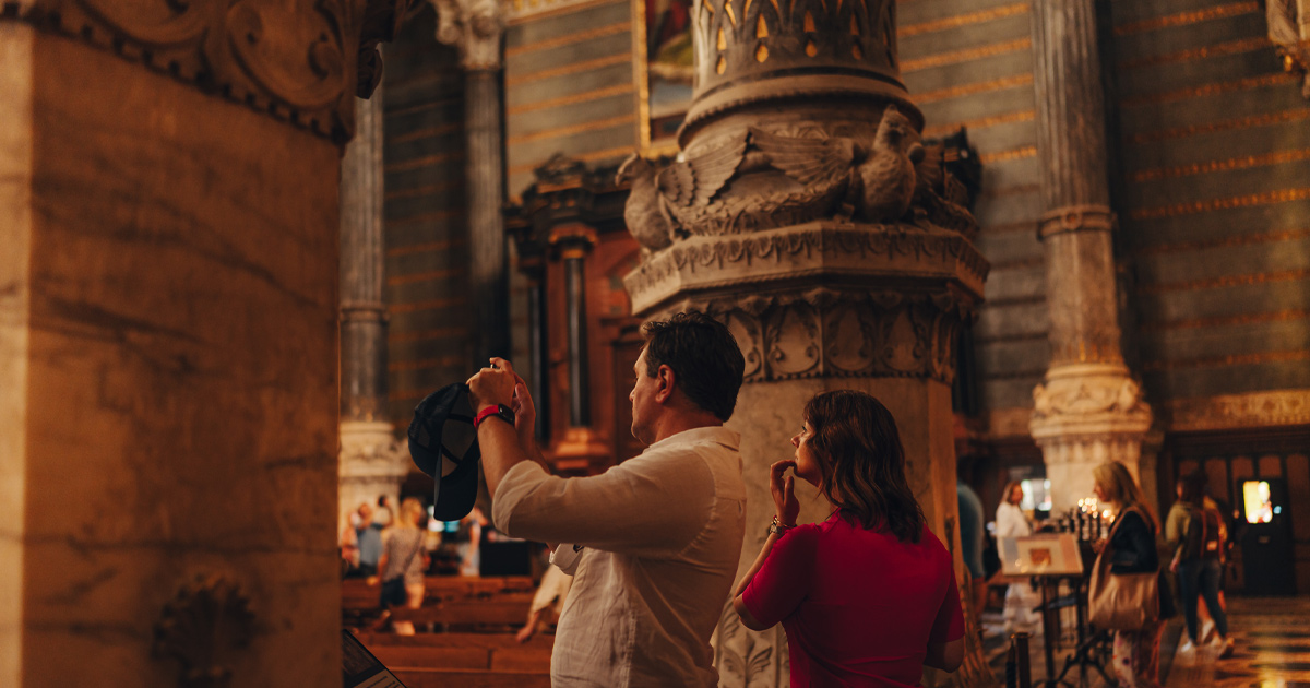 A man and woman taking pictures of Lyon’s architecture as part of an Ultimate Driving Tours experience