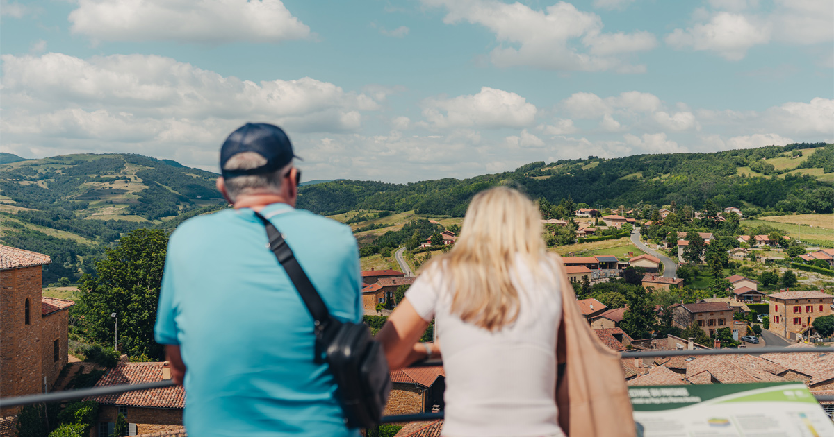 A man and woman seen from behind as they admire a valley view in southern France