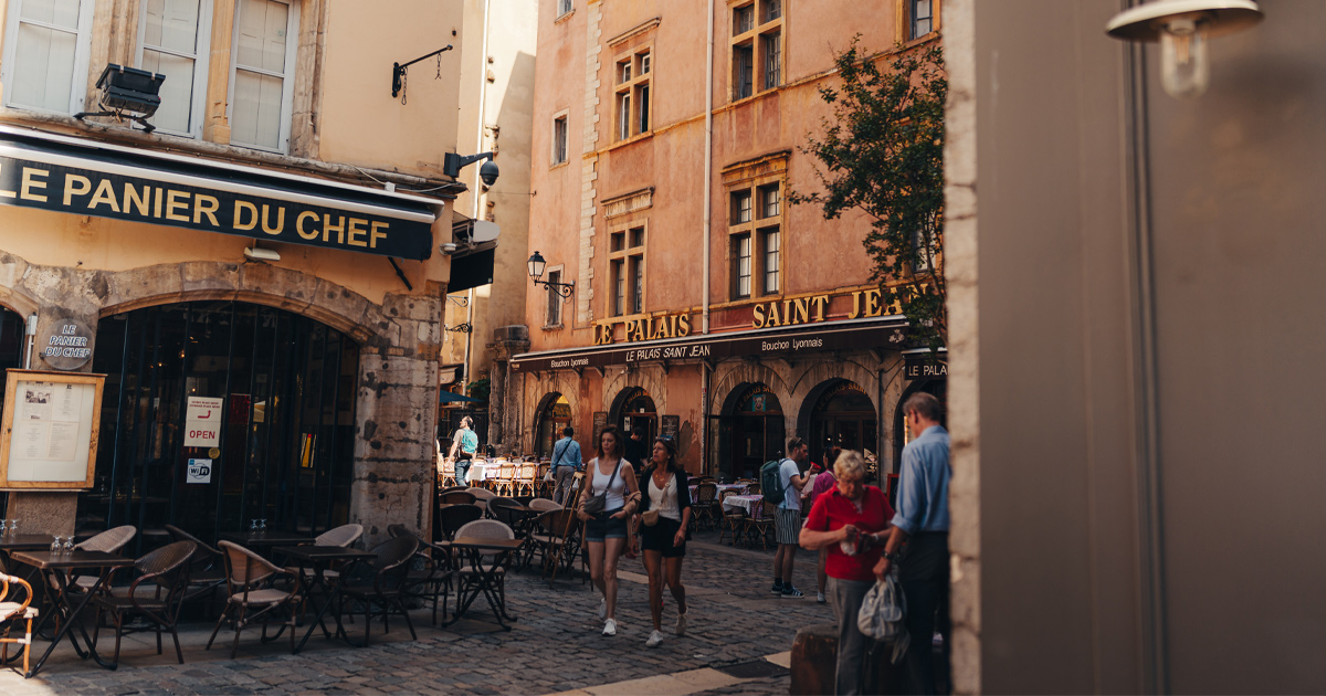 Tourists roaming the backstreets of Lyon with a variety of stone buildings, bakeries and cafes