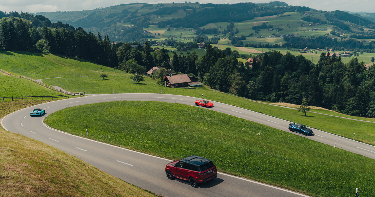 A red Range Rover performing the sweep car role on a European luxury tour