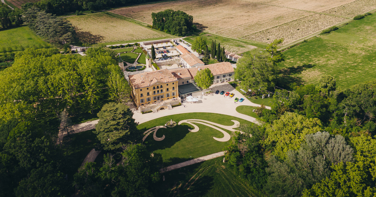An aerial view of a large French country estate with manicured lawns and gardens