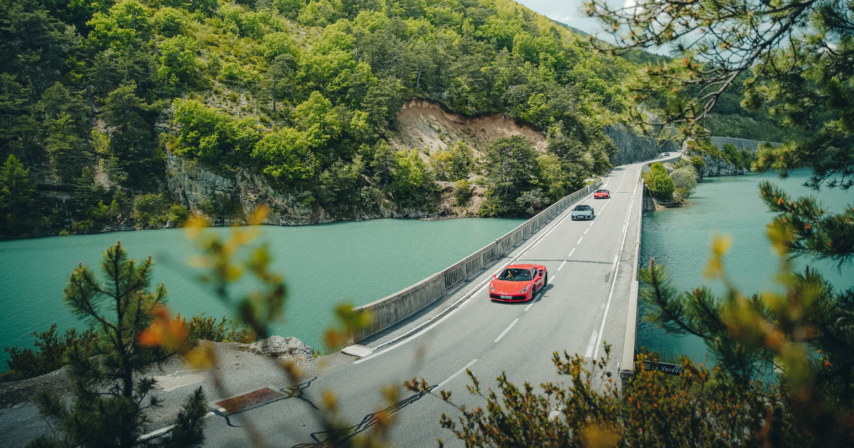A convoy of supercars crosses a large river in France