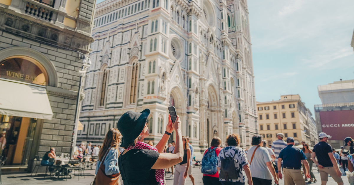 Tourists admire the views in a bustling piazza in Florence on a sunny day