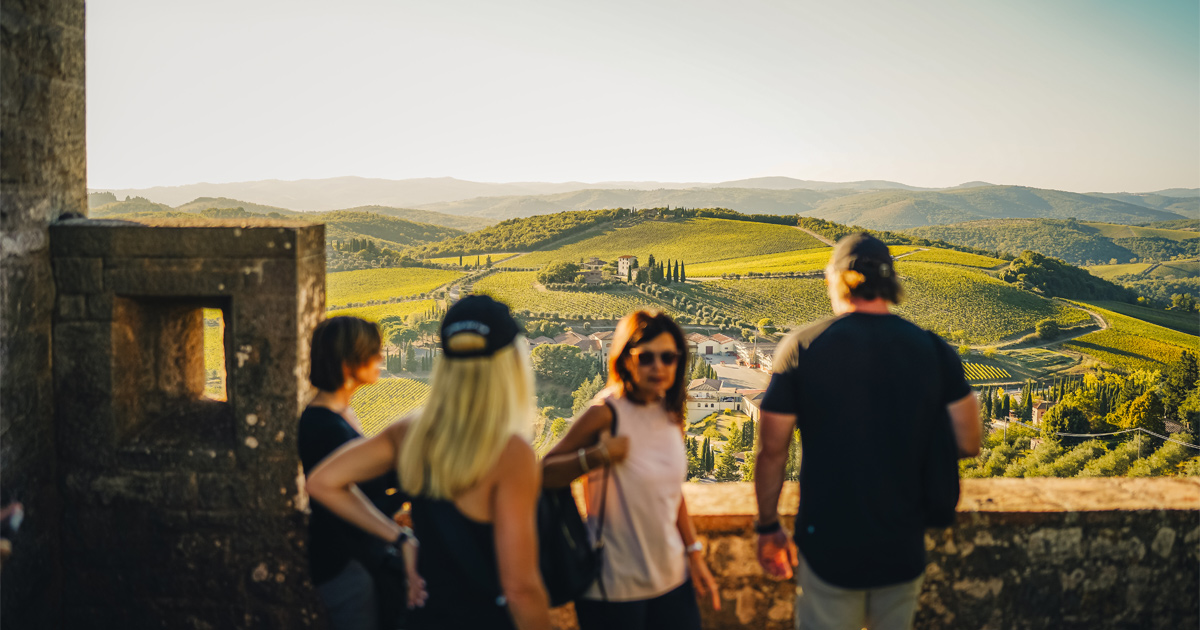 Ultimate Driving Tours’ guests admire a panorama of rolling green valleys in Tuscany from a balcony