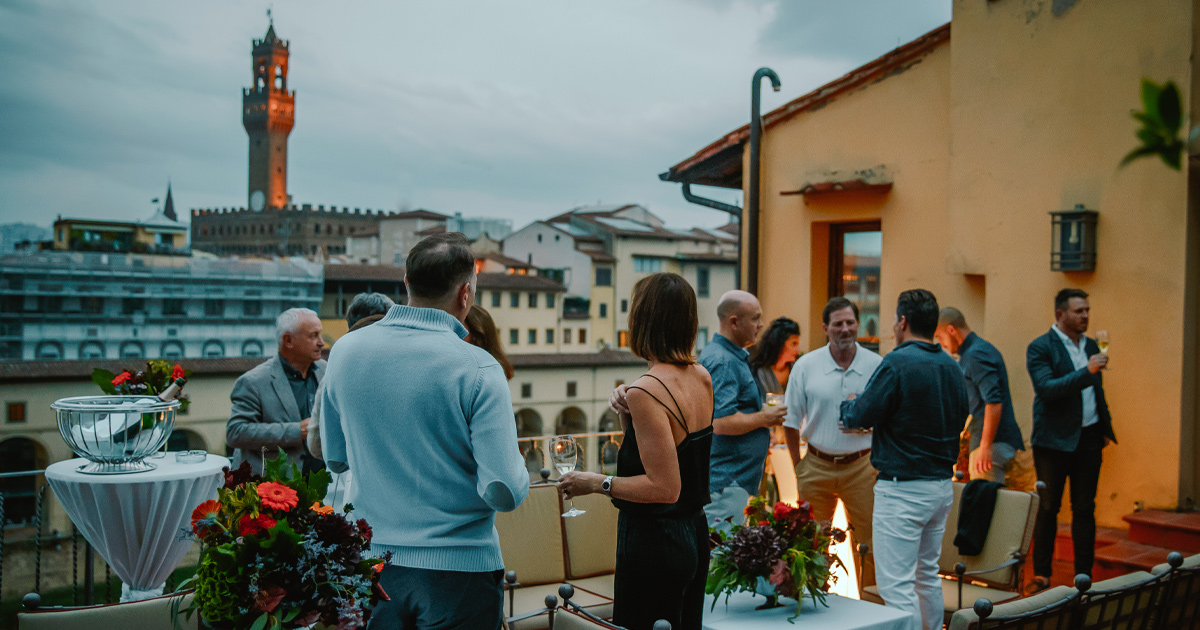 Ultimate Driving Tours’ guests chatting with drinks on a rooftop in Florence