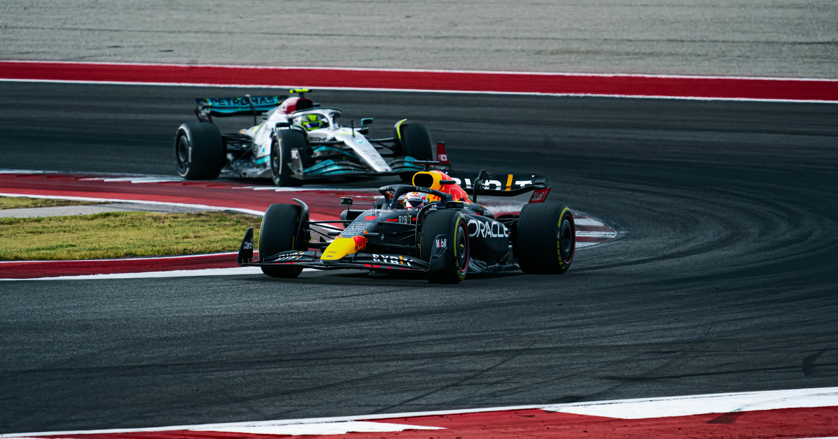 Max Verstappen in his blue Red Bull car leading a silver F1 car round a corner at the Circuit of the Americas