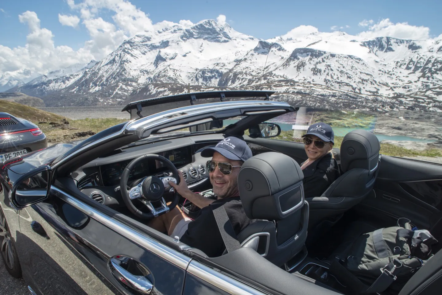 Couple smiling in a supercar as they drive the French Alps on a luxury tour of Europe